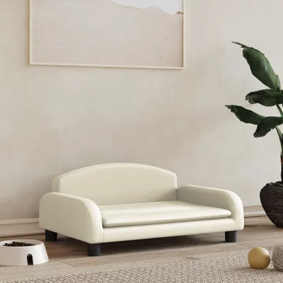 A cream-colored pet bed is shown in a room with a plant and a framed picture on the wall.