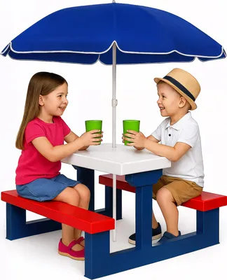 Two children are sitting at a picnic table with an umbrella, holding cups.