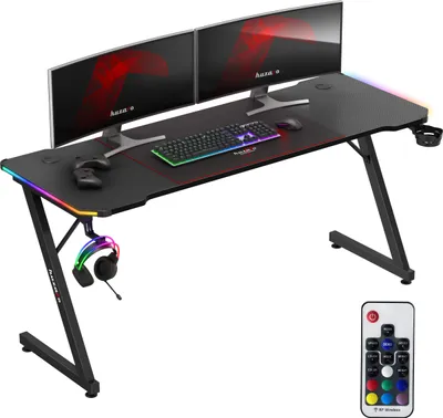 A gaming desk setup with dual monitors, keyboard, mouse, and headphones, featuring RGB lighting.