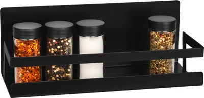 A black magnetic spice rack with four spice jars on a black background.
