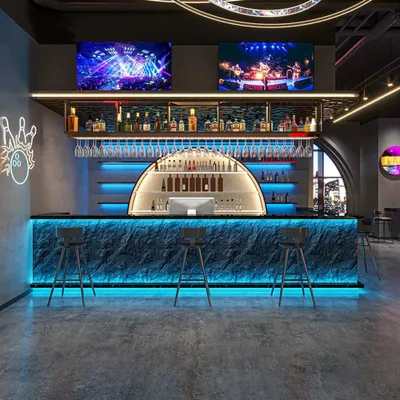 A modern bar interior with a prominent illuminated bar counter and stools, shelves stocked with bottles, and screens displaying visuals.