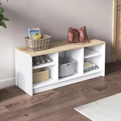 A shoe cabinet with storage compartments is placed in an entryway, with a handbag and magazines on top.