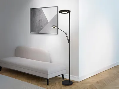 A modern living room with a white sofa and a black LED floor lamp with a reading lamp.