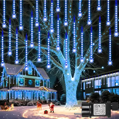 A house decorated with blue Christmas lights during a snowy night.