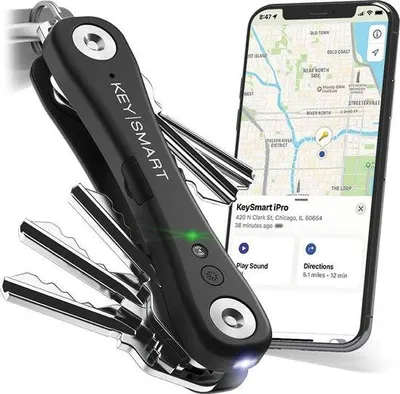 A black KeySmart iPro keychain is shown next to a smartphone displaying a map and location information.