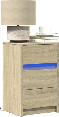 A wooden nightstand with a lamp and a cup on top.