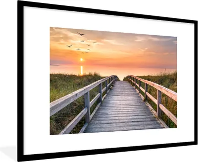 Produktbild von MuchoWow® Gerahmtes Poster Sonnenuntergang - Meer - Weg - Gras - Düne - Vögel 90x60 cm - Poster mit Schwarzem Bilderrahmen Wandposter Rahmen Foto Bilder - Wanddekoration - Fotos