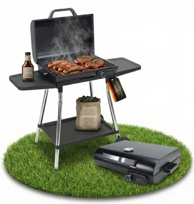 A grill with food cooking on it, a bottle of sauce, and a bag of charcoal, set on a patch of grass with a second grill in the foreground.