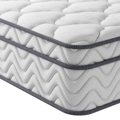 A close-up, angled view of a white mattress with a quilted surface and a dark gray trim along the edges.