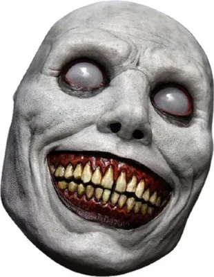 A close-up of a scary demon mask with a wide, toothy grin and blank white eyes.