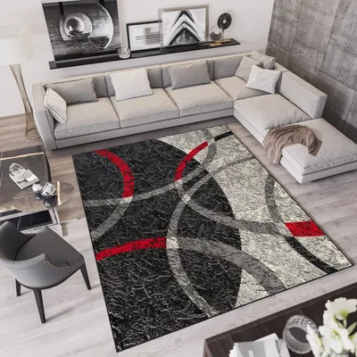 A modern living room with a sectional sofa, coffee table, and a large area rug.
