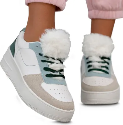 Close-up of two women's sneakers, one in focus and the other slightly blurred, worn by a person with pink pants.