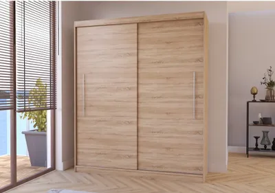A sliding door wardrobe in a room with blinds and a plant visible through a window.
