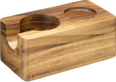 A close-up studio shot of a wooden tamping station with two circular cutouts.