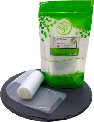 A roll of plastic casings is shown next to a bag of plastic casings, on a dark circular surface.