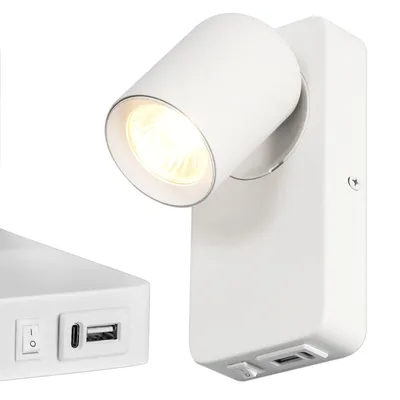 A white wall lamp with a spotlight and USB ports is shown against a white background. Another part of the lamp is visible to the left.