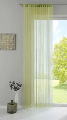 A sheer green curtain hangs in front of a window with a view of trees.