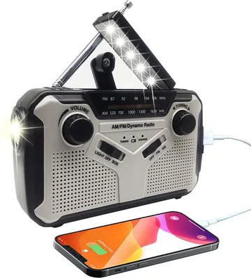A portable AM/FM radio with a flashlight and a charging cable connected to a smartphone.