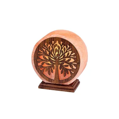 A Himalayan salt lamp with a carved wooden tree of life design.