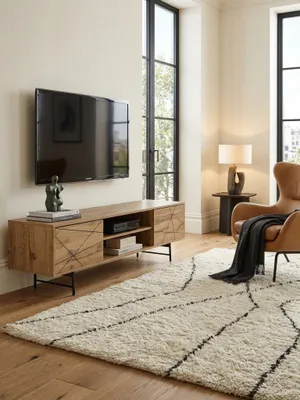 Modernes TV-Lowboard aus Eichenholz-Dekor im Wohnzimmer, 160 cm breit, mit schwarzem Liniendesign und Metallbeinen, stilvoll dekoriert._#sku_SAFWL6.579#