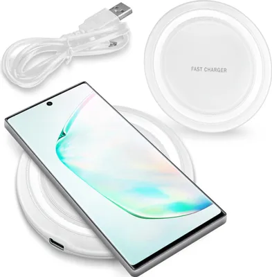 A smartphone is placed on a wireless charging pad, with a USB cable nearby.