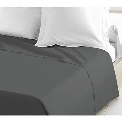 A close-up view of a bed with gray sheets and white pillows.