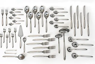 A collection of stainless steel cutlery arranged on a white background.