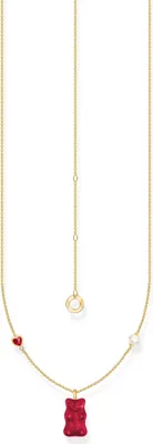 A gold necklace with a red gummy bear pendant, a red heart charm, and a white pearl charm.