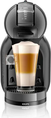 A black Krups Nescafé Dolce Gusto coffee machine with a layered latte in a glass in front of it.