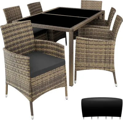 A rattan dining set with a glass-topped table and six chairs, along with a separate black cover for the table.