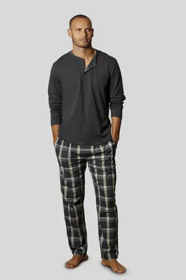 A man is standing and posing for a product image, wearing pajamas.