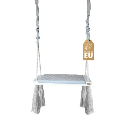 A baby swing with a quilted seat and tassels, hanging from ropes.