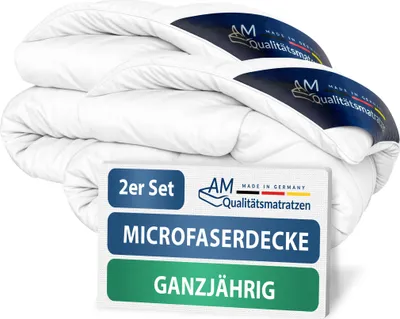A stack of white duvets with a label in the foreground.