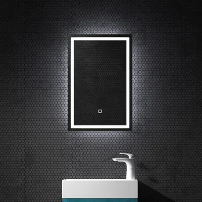 A modern bathroom vanity with a lit mirror and faucet.
