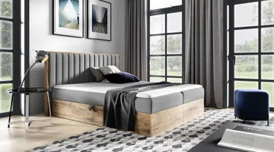 A bedroom scene with a bed, nightstand, and artwork.