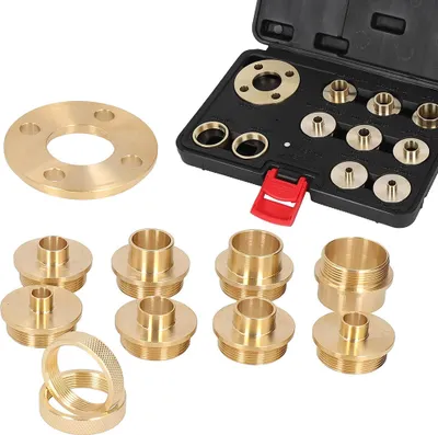 A set of brass router template bushing guides and a flange are laid out on a white background. Some of the guides are inside a black carrying case.