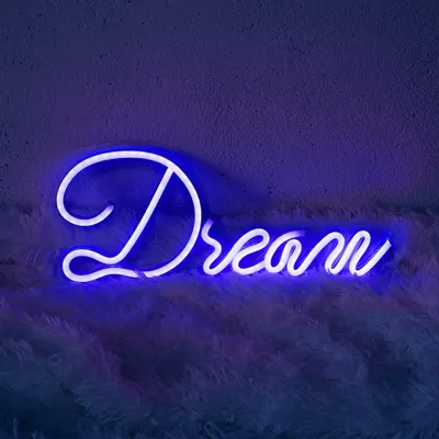 A blue neon sign spelling 'Dream' is mounted on a textured purple wall above a fluffy white rug.