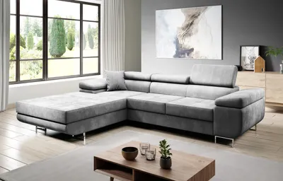 A modern living room with a large sectional sofa, a coffee table, and a large window with curtains.