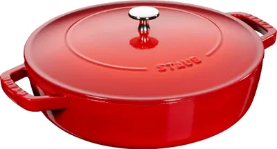 A red Staub cast iron pot with a lid is shown from a slightly elevated side angle against a white background.