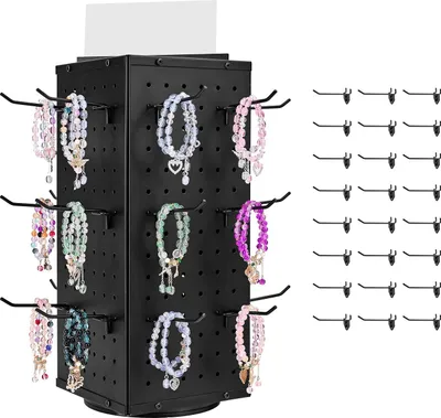 A black rotating display stand for jewelry with several bracelets on display, and a set of hooks to the right.