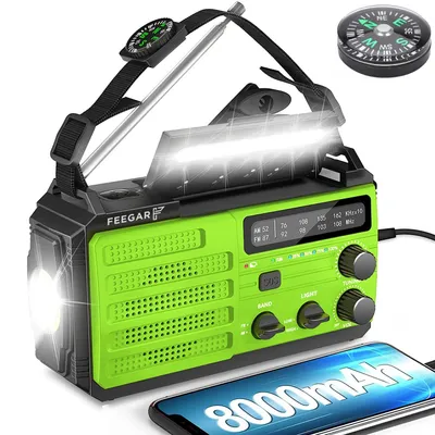 A green and black emergency radio with a flashlight and a compass attached.
