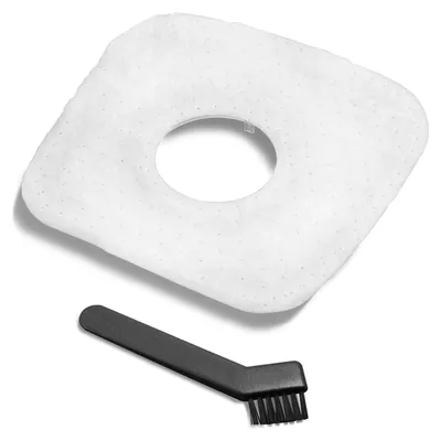 A white filter pad and a black cleaning brush are shown against a white and light gray background.