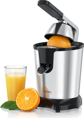 A citrus juicer with a glass of orange juice, half an orange, and leaves.