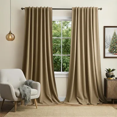 A cozy living room scene with a chair, curtains, and a window view.