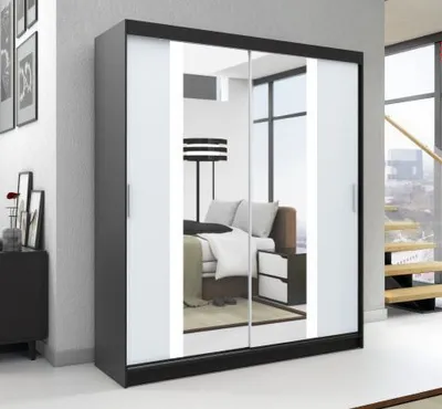 A modern sliding door wardrobe with mirrored doors, reflecting a bedroom interior.