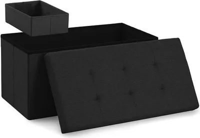 A black storage ottoman with its lid open, and a small black storage box placed on top of the ottoman.
