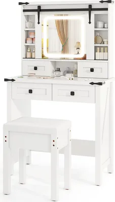 A white vanity table with a stool and a lighted mirror.