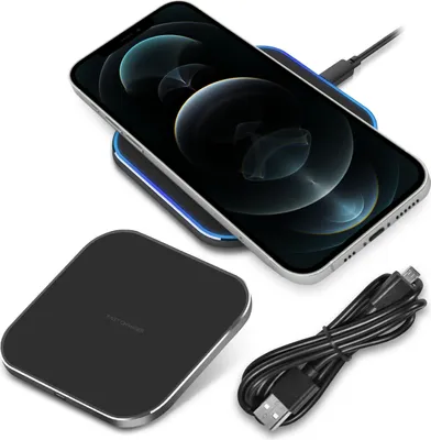 A smartphone is wirelessly charging on a black wireless charger. A black USB cable is also visible.