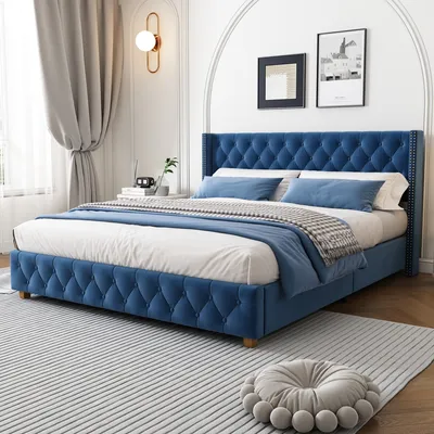 A blue upholstered bed with pillows and a blanket in a bedroom setting.