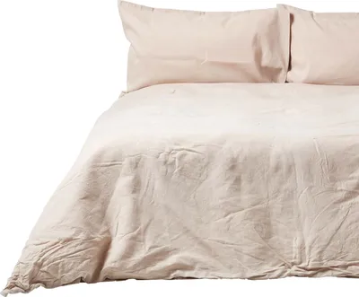 A close-up view of a beige linen duvet cover and two pillowcases on a bed.